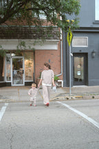 a woman and child walking on a street